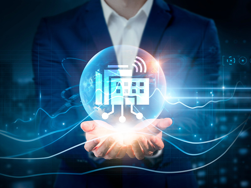 Business professional holding a glowing digital sphere with smart building icons, symbolising innovation enabled by AMR energy meters and BMS audits.