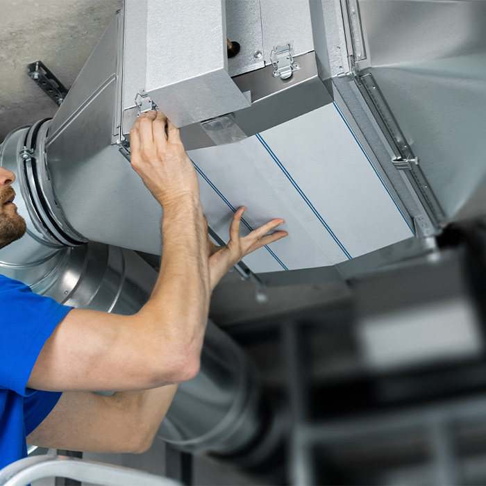 Engineer inspecting ventilation ductwork during a tm44 inspection to assess system efficiency and maintenance adequacy.