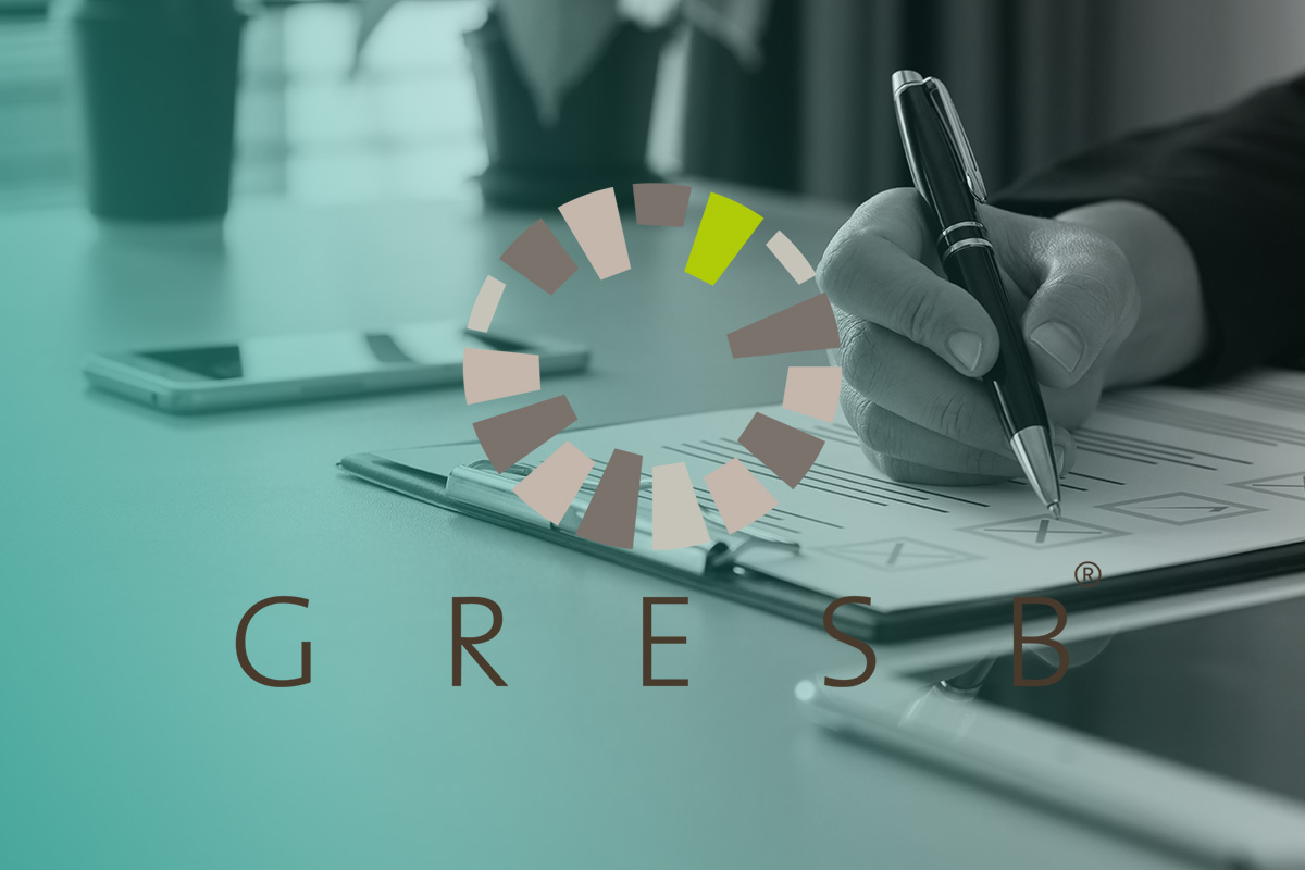 “A person completing sustainability documentation on a clipboard with the GRESB circular logo overlaid, representing the GRESB (Global Real Estate Sustainability Benchmark) Compliance and Strategy Service.”