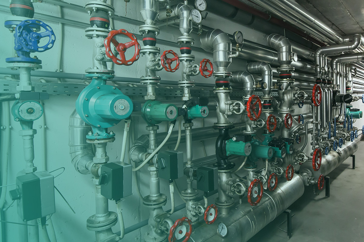 “Complex network of valves, pumps, and insulated pipework in a plant room supporting Heat Metering systems for accurate energy measurement.”
