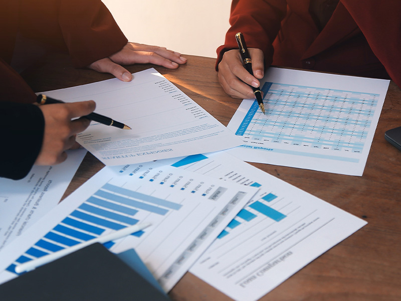 Close-up of professionals reviewing data charts and reports, symbolising expert guidance and management throughout the basket energy procurement process.
