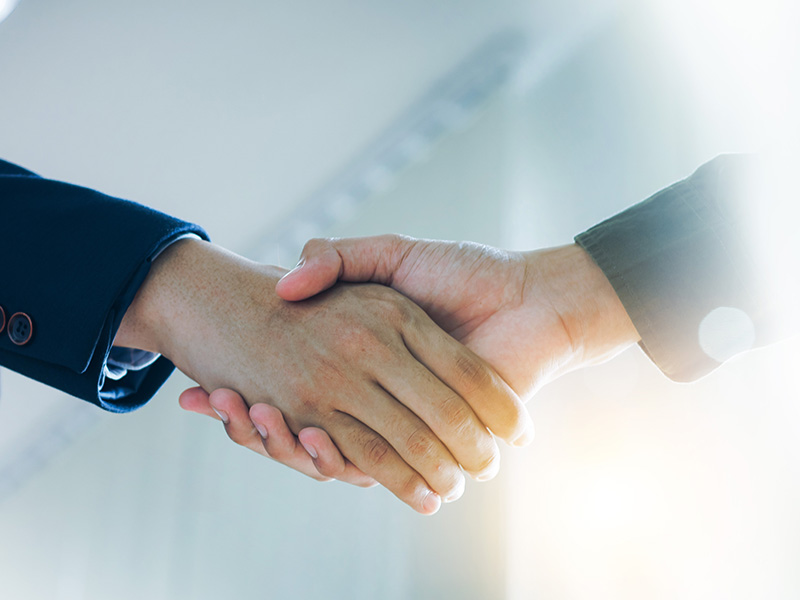Close-up of a handshake, symbolising trust and partnership built on energy market intelligence for procurement strategies.
