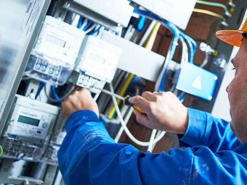 Engineer working on electrical systems and wiring, illustrating the role of AMR energy meters and BMS audits in smarter energy management.