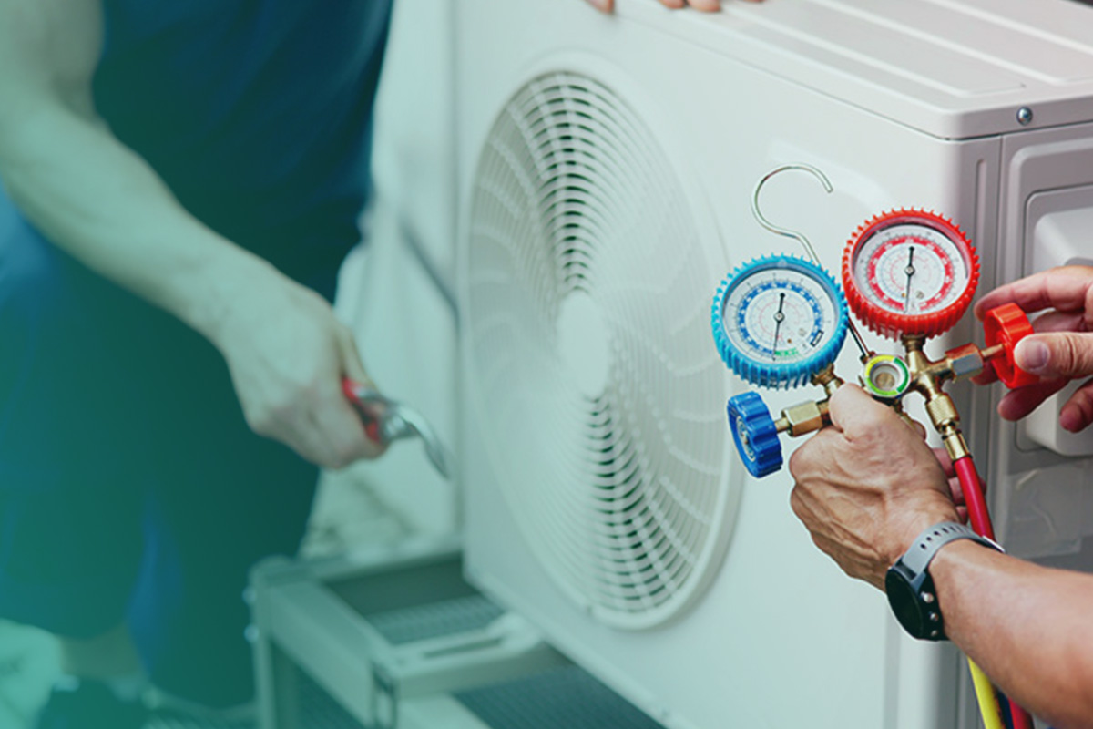 “A technician using pressure gauges to assess an air conditioning unit during a tm44 inspection.”