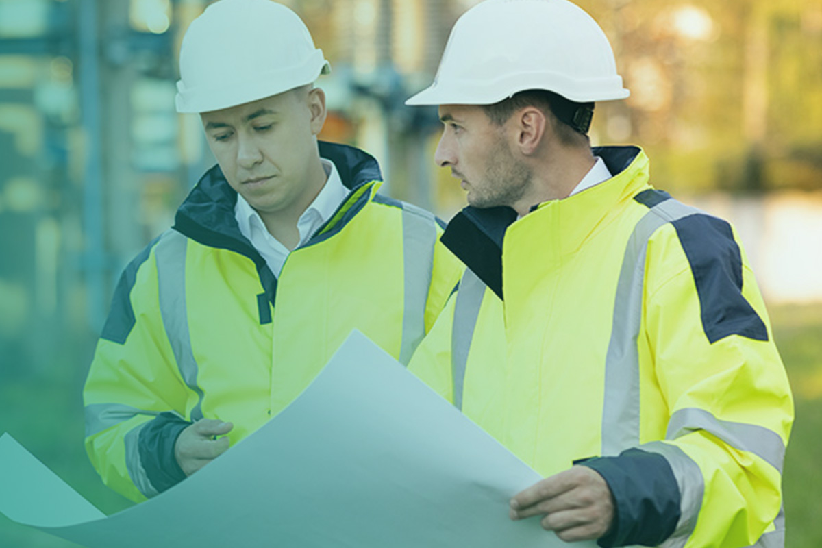 “Engineers reviewing site plans during a track and trace survey for commercial buildings.”