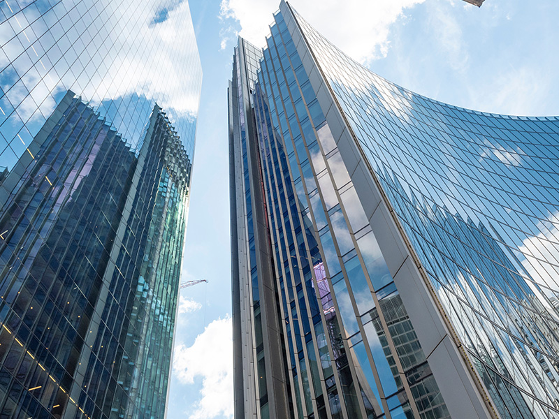 Tall modern office buildings against the sky, symbolising the organisations and sectors that can benefit most from basket energy procurement.