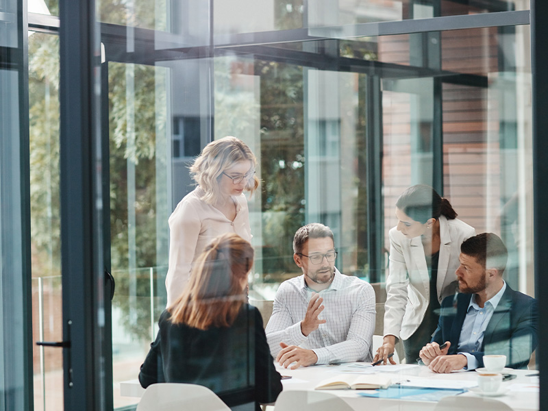 Group of professionals in a meeting room discussing strategies, symbolising how energy market intelligence for procurement supports business decision-making.