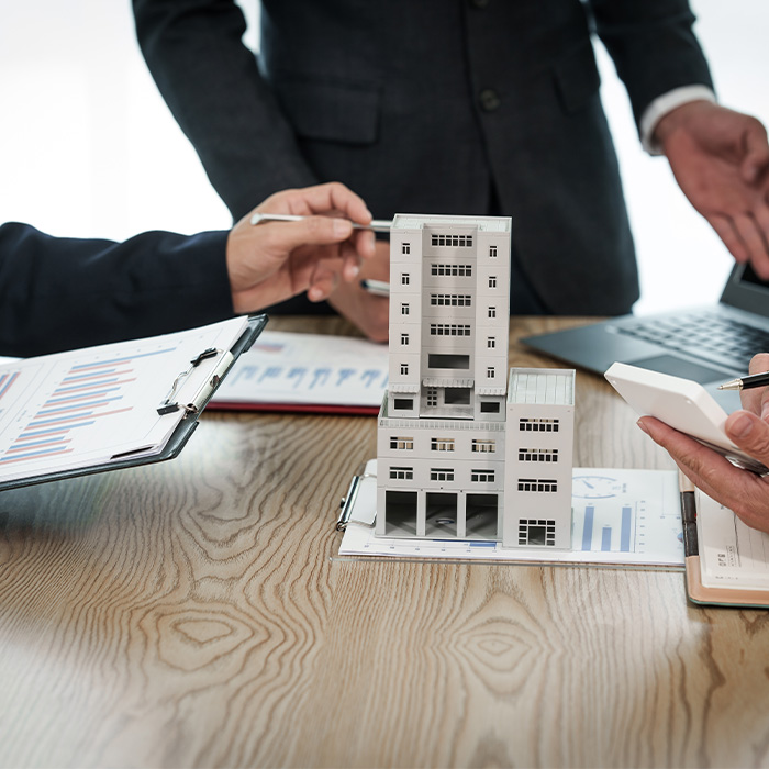 Business professionals evaluating a building model and performance data as part of an Energy audit.