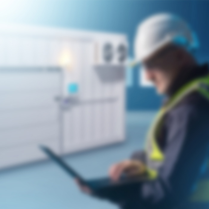 Accredited energy assessor conducting a TM44 inspection on commercial air conditioning systems with a digital tablet.