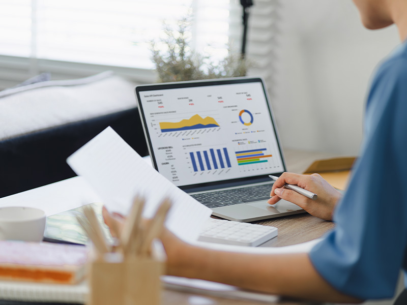 Professional analysing graphs and charts on a laptop, illustrating the role of energy market intelligence for procurement in decision-making.