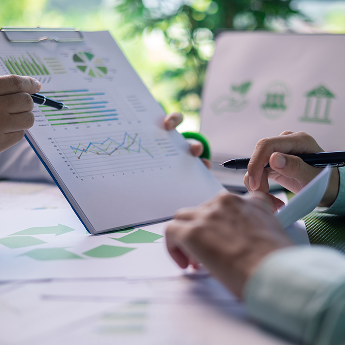 Energy management specialists reviewing sustainability charts and performance graphs during a strategy meeting.