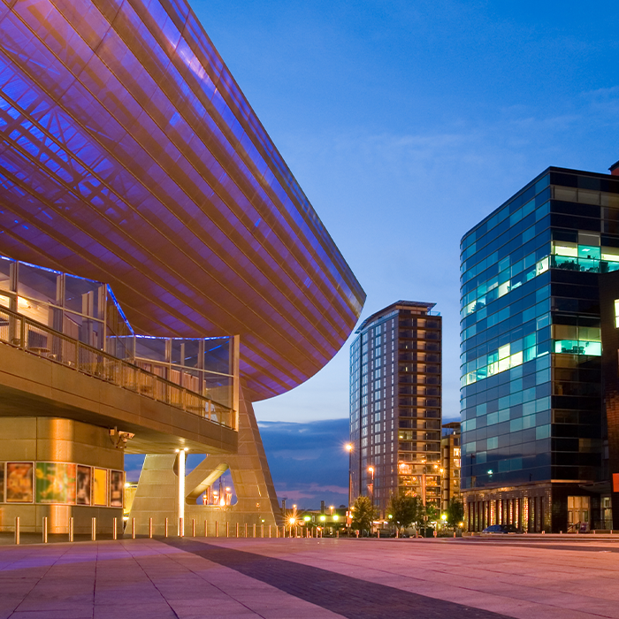 Modern commercial and public sector buildings at dusk, reflecting the diverse environments supported by energy management specialists.