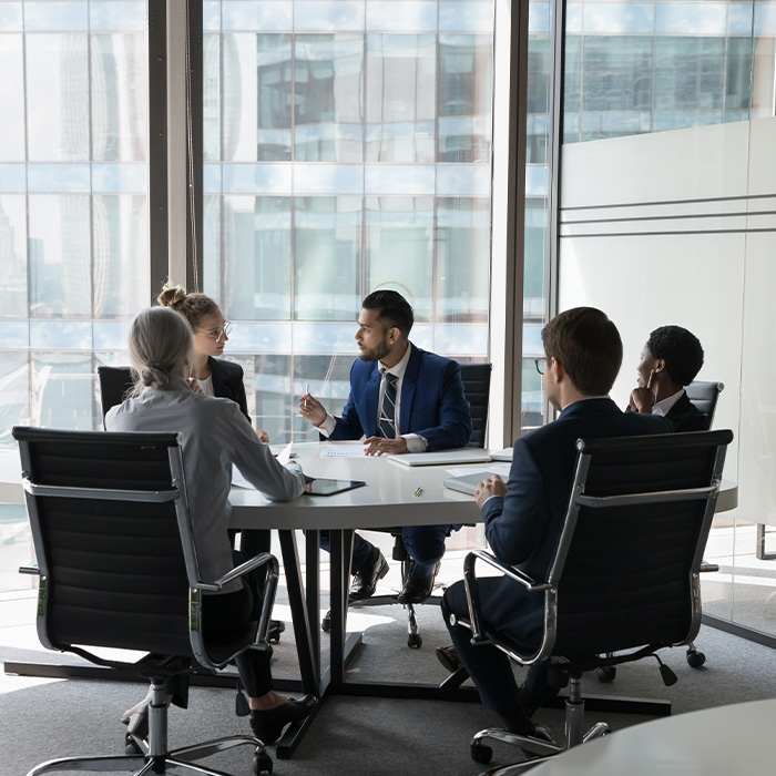 Professionals in a boardroom meeting discussing MEES compliance services for commercial properties.