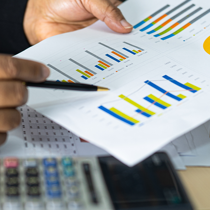 Person reviewing printed bar charts and energy usage data during ESOS compliance preparation.