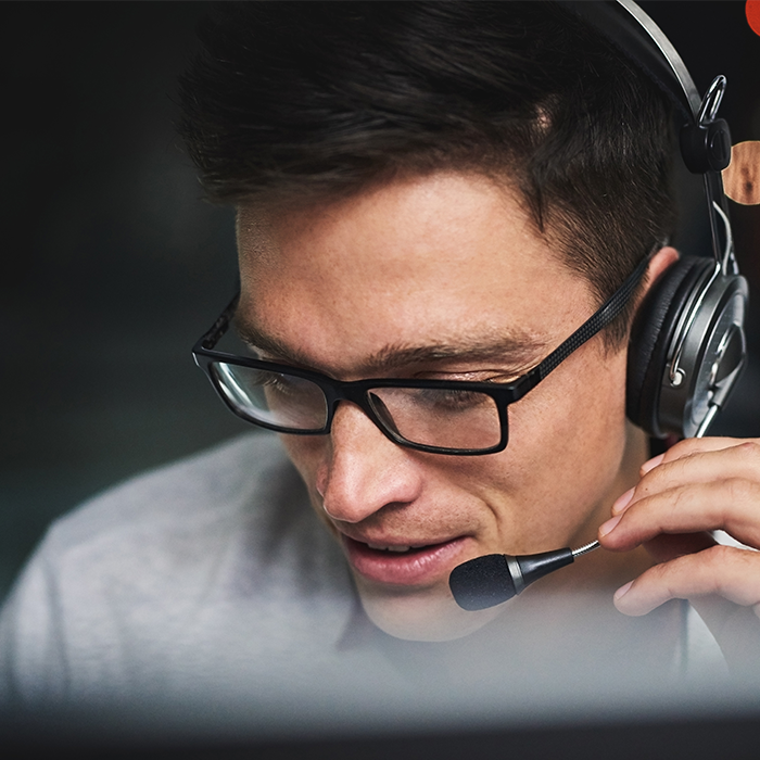 Man wearing a headset and glasses, providing real-time customer support for a business electricity provider.