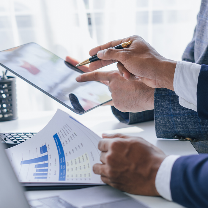 Business professionals reviewing ESOS Phase 3 data on a tablet and printed report during a compliance meeting.