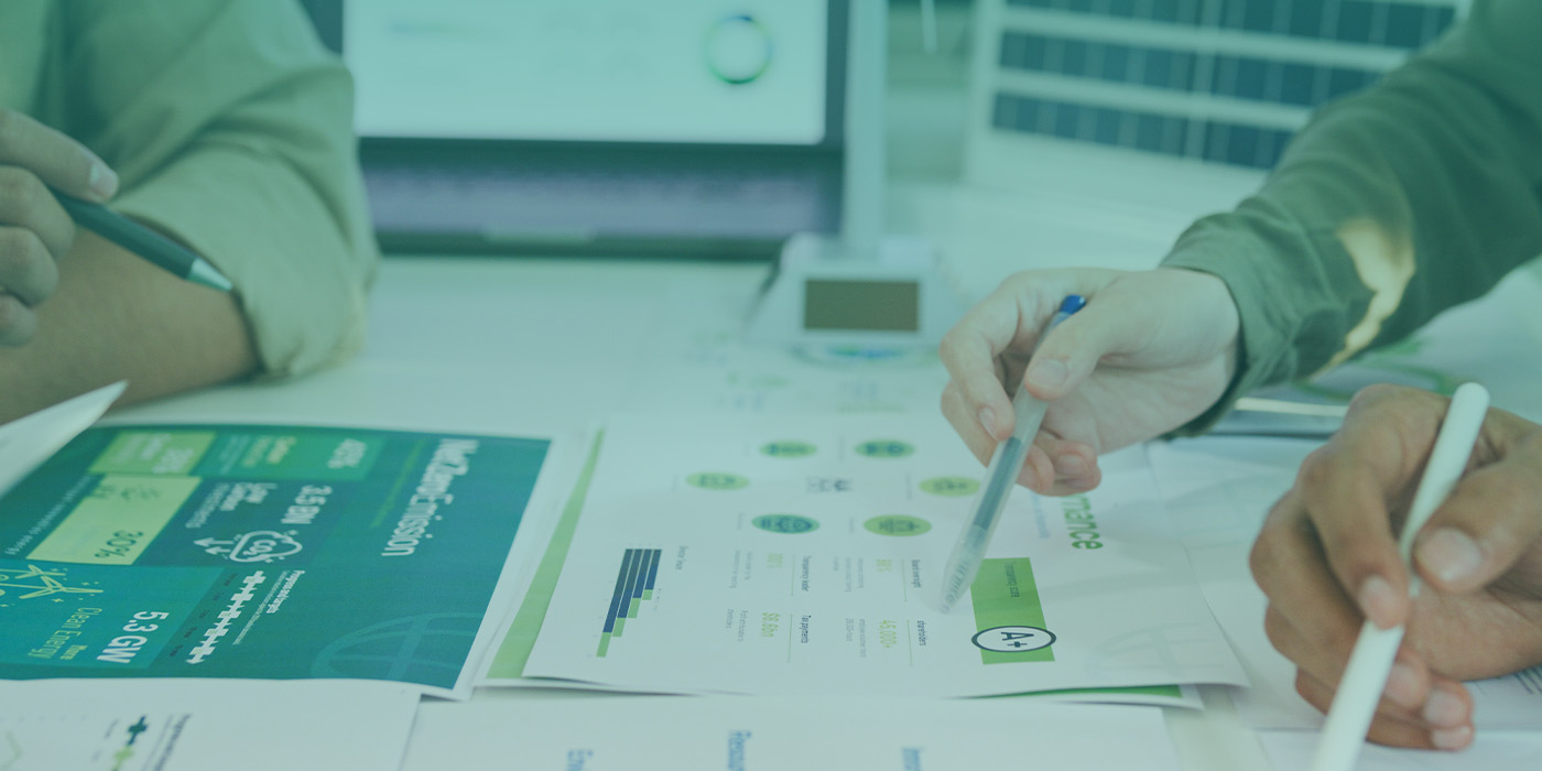 Hands reviewing sustainability data and energy performance charts — highlighting the top 5 benefits of working with energy management specialists.