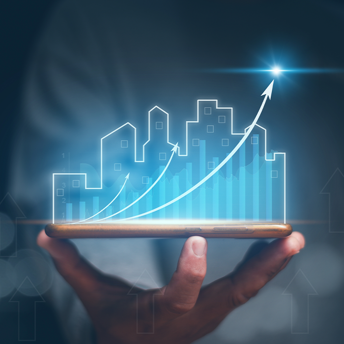Hand holding a smartphone with a digital cityscape and upward growth arrows, representing the benefits of AMR metering.