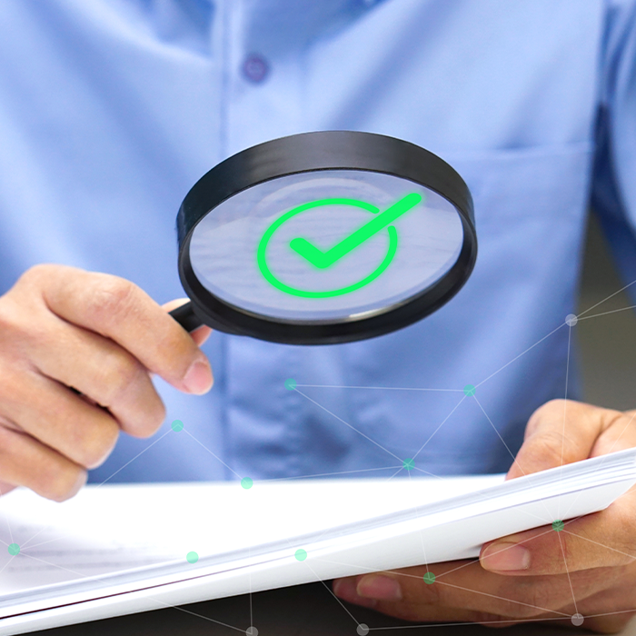 Person holding a magnifying glass over a document, symbolising the accuracy checks involved in bill validation.