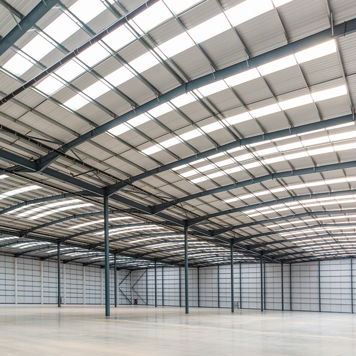 Spacious, empty industrial warehouse subject to MEES regulations for energy performance compliance.