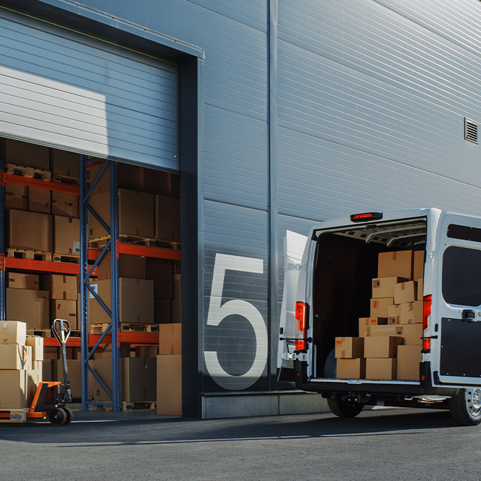 Logistics warehouse and delivery van illustrating net zero procurement in the supply chain.