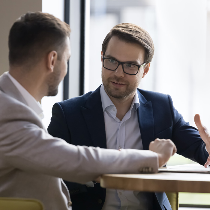 Two business professionals in discussion at a table, reviewing strategy options related to Flexible Energy Procurement.