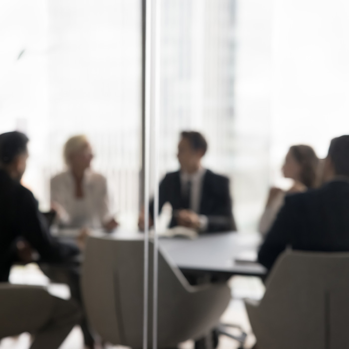 Business professionals in a boardroom discussing net zero procurement strategies.