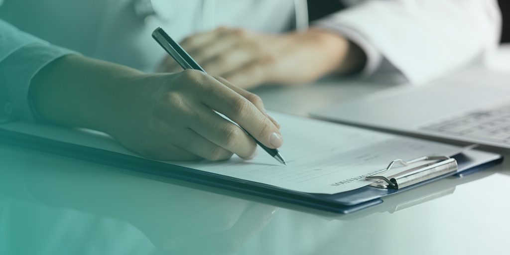 Close-up of a hand filling out a compliance form on a clipboard, symbolising SECR compliance report preparation.
