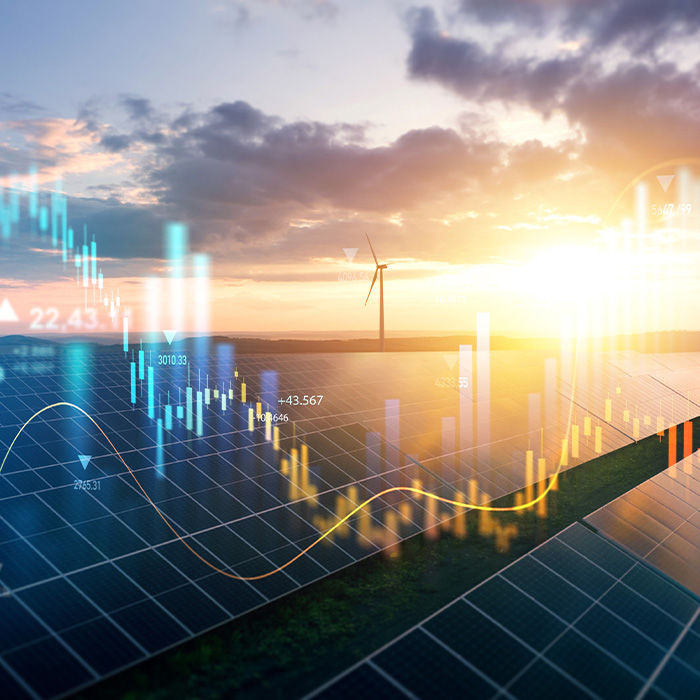 Overlay of financial graphs on solar panels and wind turbines at sunset, symbolising the benefits of Flexible Energy Procurement.