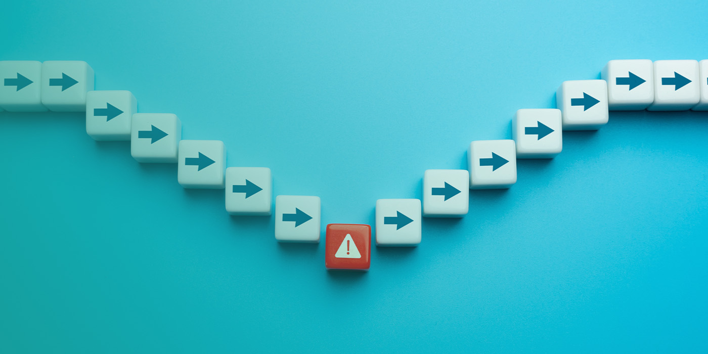 Row of blocks with arrows pointing forward, disrupted by a red warning block, symbolising errors that can undermine EPC accuracy for commercial buildings.