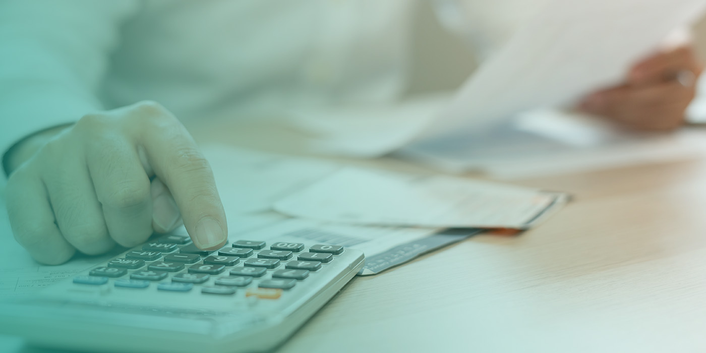 “Person using a calculator with bills on the desk, illustrating common Energy Procurement Mistakes related to overlooked debts and account issues.”