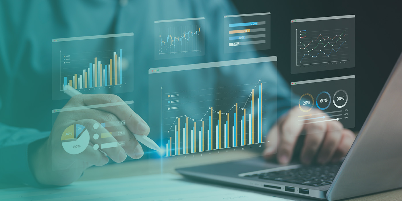 A professional reviewing digital dashboards on a laptop and tablet, analysing charts and graphs to improve Energy Data Accuracy.