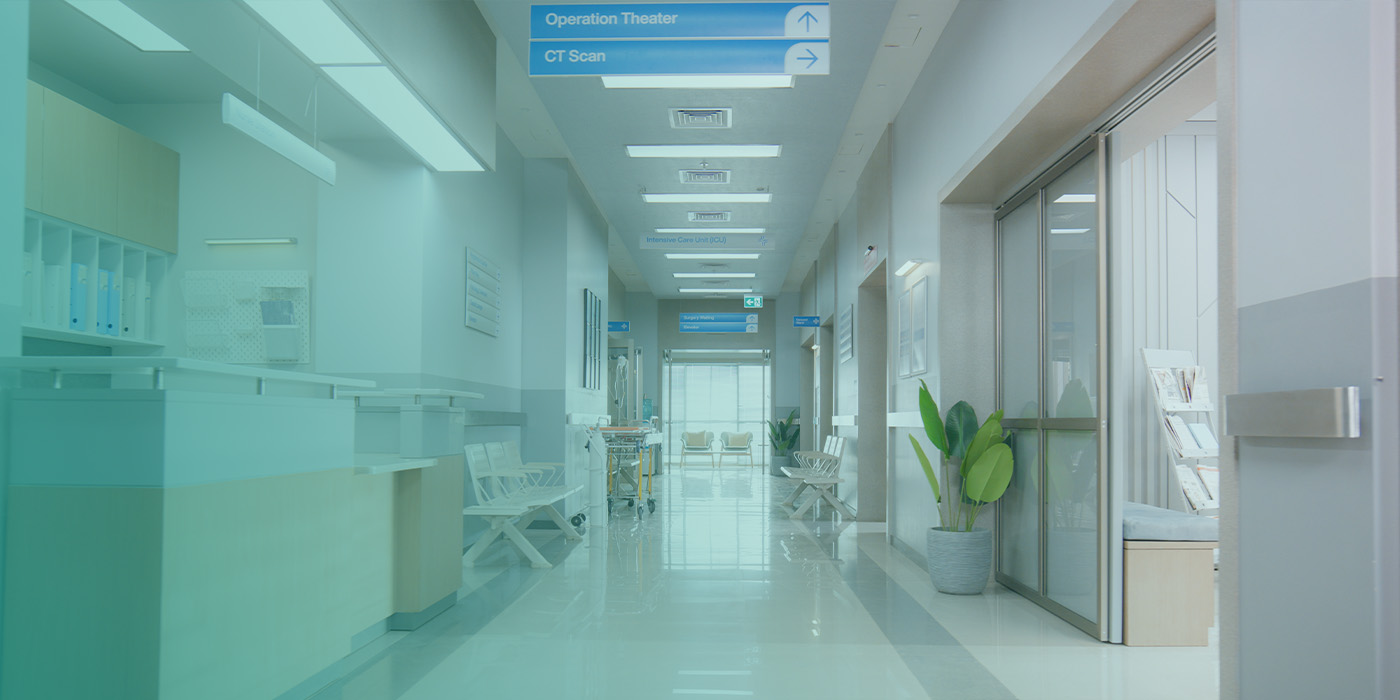 Hospital corridor with clinical workstations and patient areas, illustrating how BMS Optimisation enhances safety, comfort, and energy control in healthcare buildings.