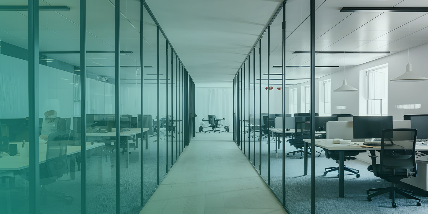 Modern office corridor with glass partitions illustrating how an Optimised BMS supports efficient lighting, HVAC control, and workspace comfort.